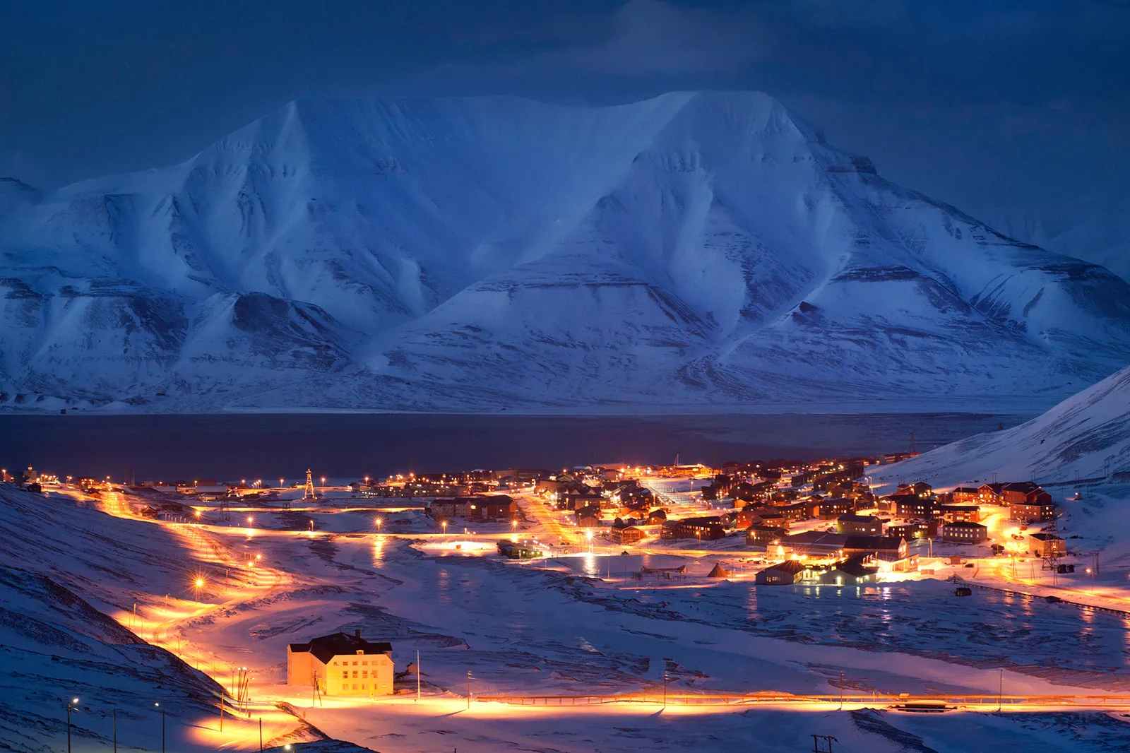 an image of svalbard at night with lights of the small buildings and houses